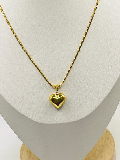 Gold heart-shaped pendant necklace on a mannequin bust.