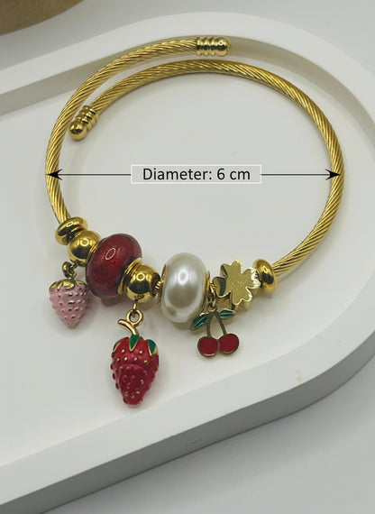 Gold bracelet with fruit-themed charms on a white background