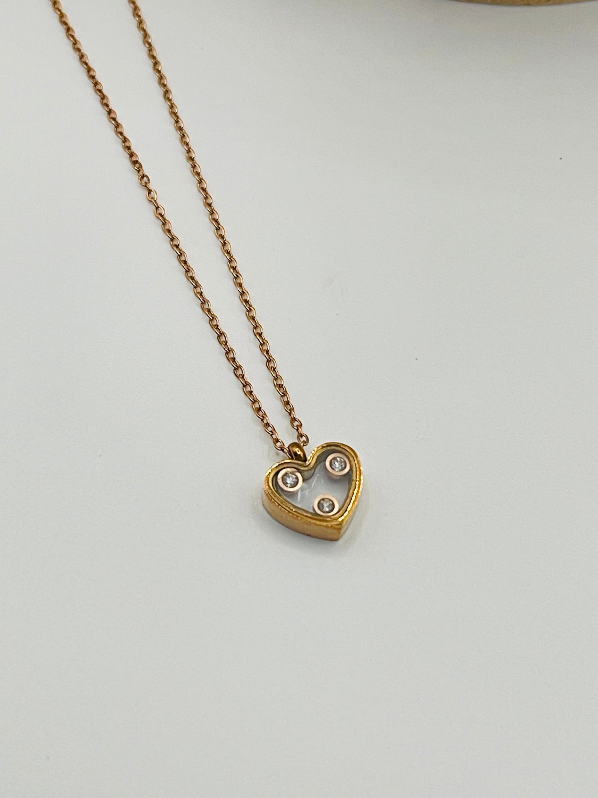 Rose Gold heart-shaped pendant necklace on a light gray background
