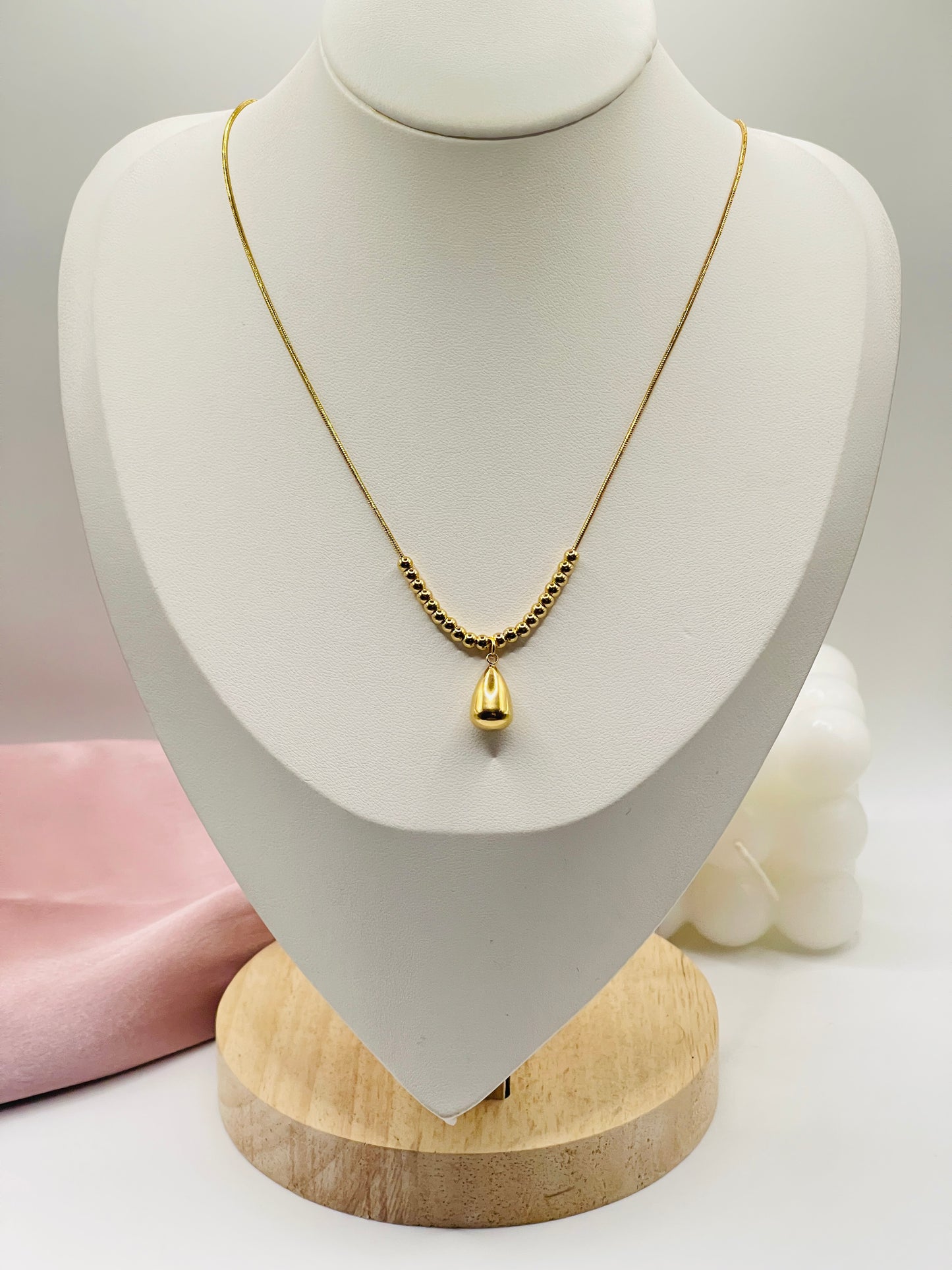 Gold necklace on a mannequin bust with a white background