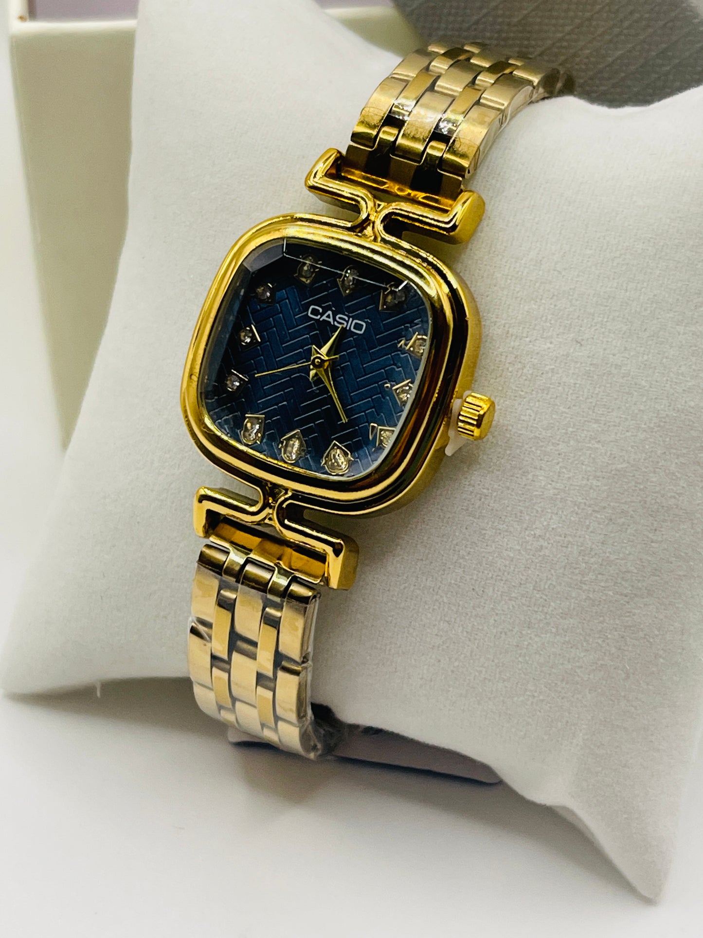 Gold Casio watch on a white cushion