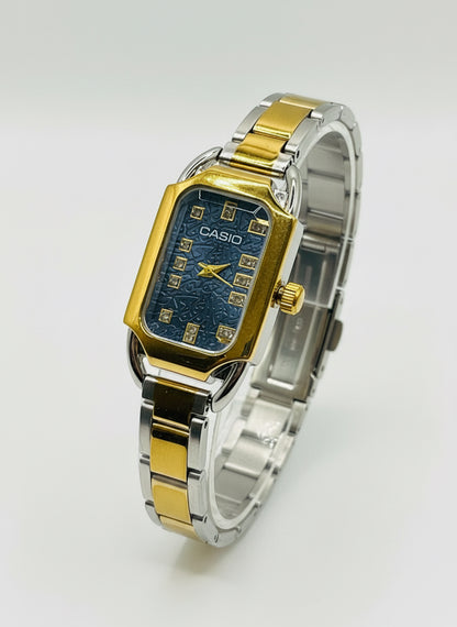 Casio watch with gold and silver band on a white cushion