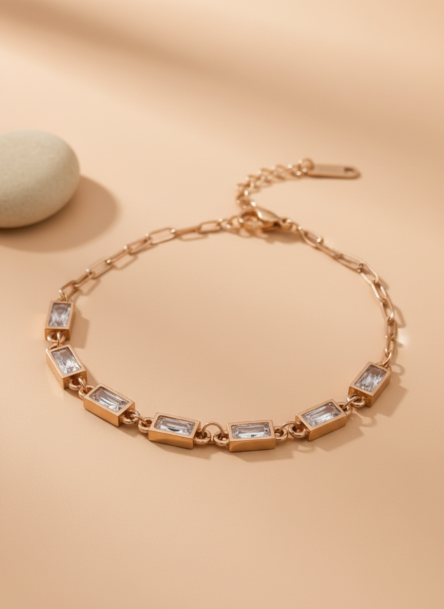 Rose gold bracelet with clear stones on a beige background