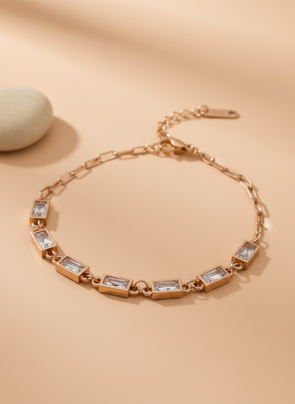 Rose gold bracelet with clear stones on a beige background