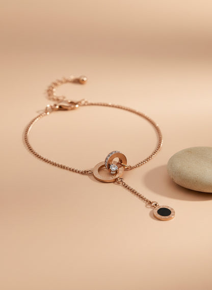 Rose Gold necklace with black pendant on a textured white surface