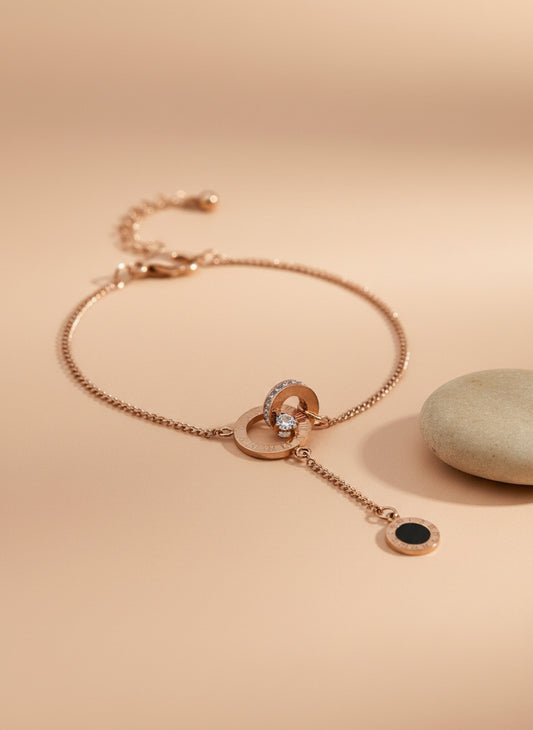 Rose Gold necklace with black pendant on a textured white surface