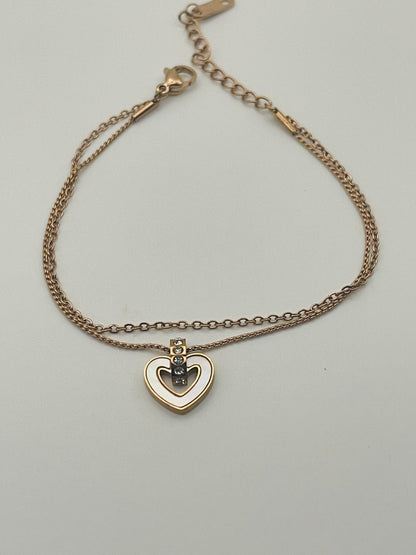 Rose Gold bracelet with a heart-shaped pendant on a light gray background