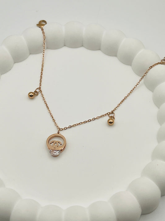Rose gold necklace with a diamond bracelet on a white beaded stand