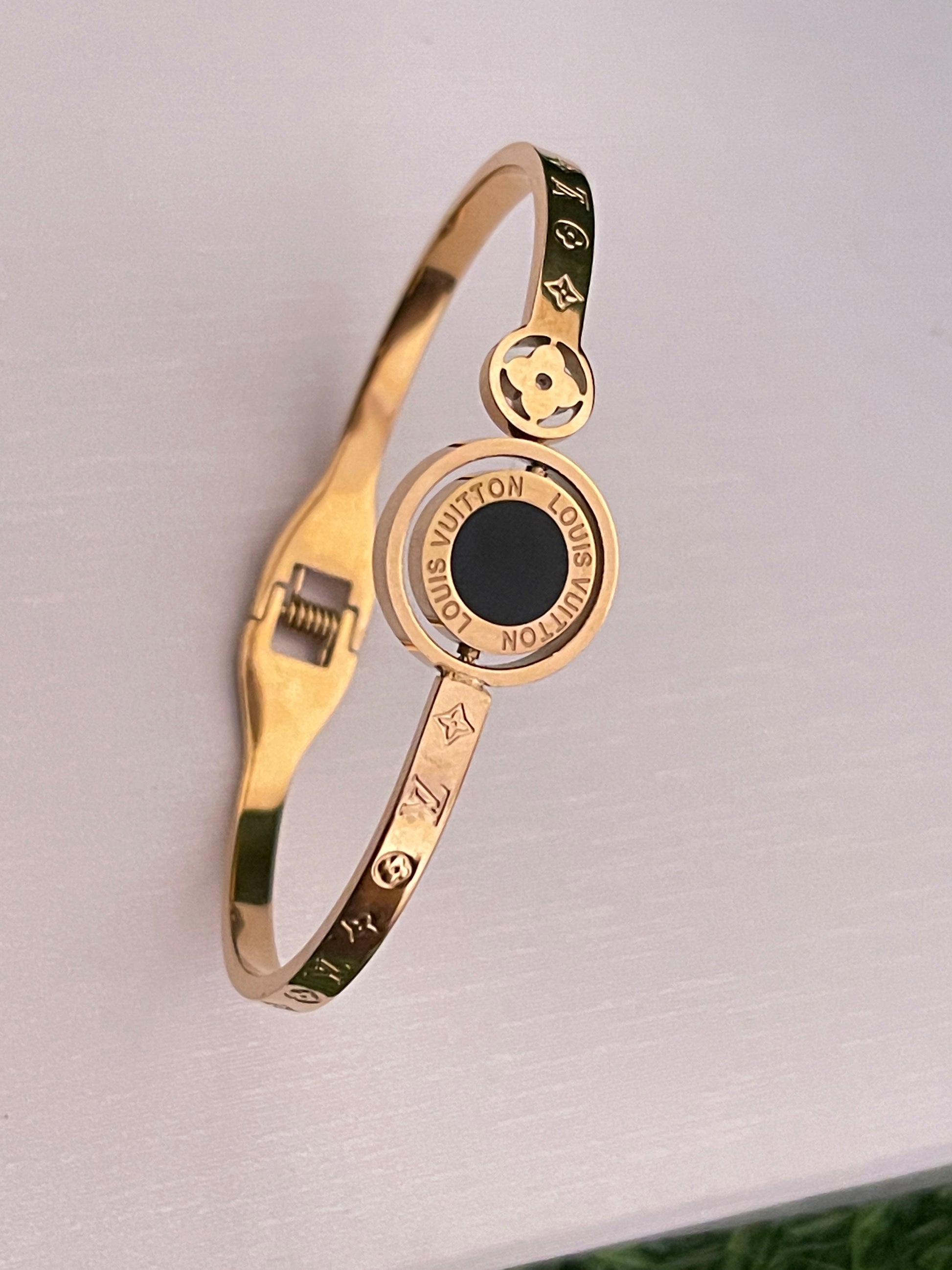 Rose Gold bracelet with a black stone on a light gray background