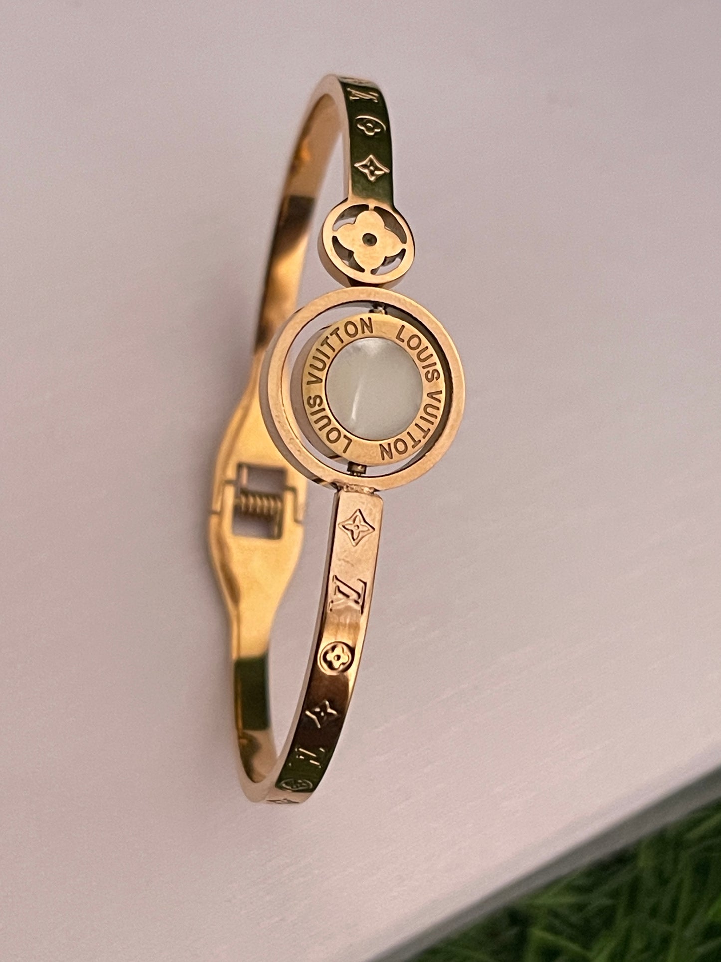 Rose Gold bracelet with Louis Vuitton logo on a light gray background