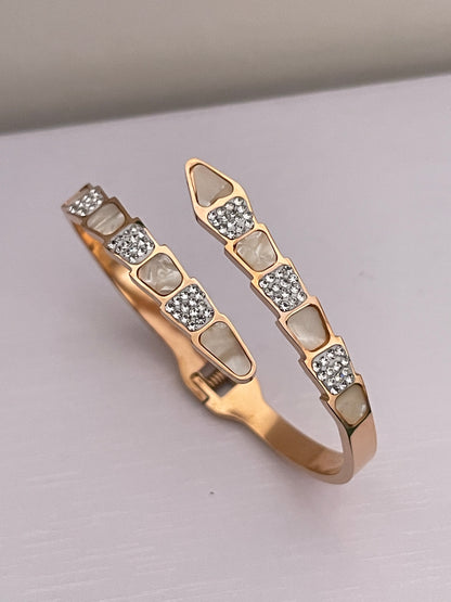 Rose Gold bracelet with embedded stones on a light gray background