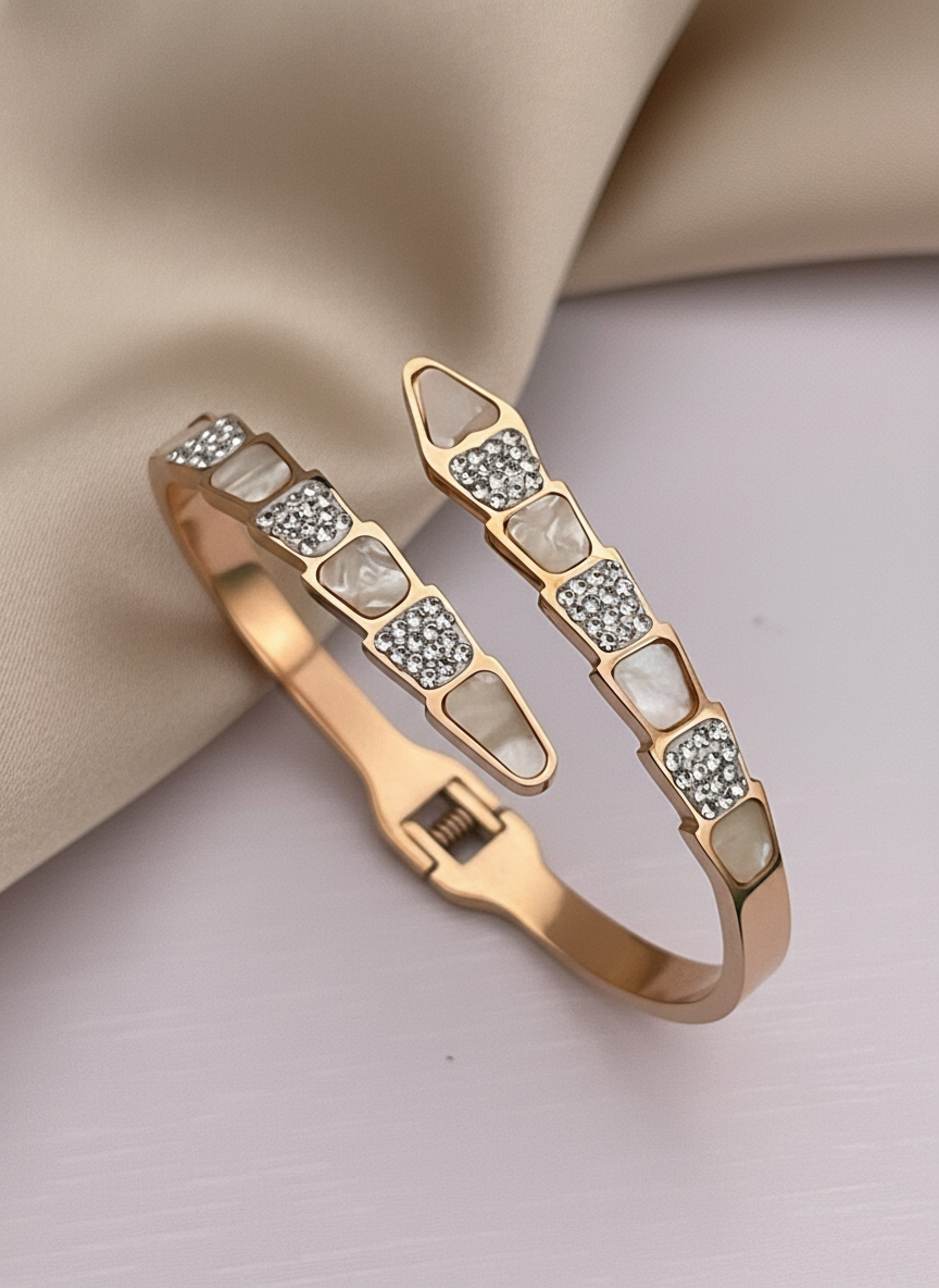 Rose gold bangles with gemstone accents on a beige fabric background