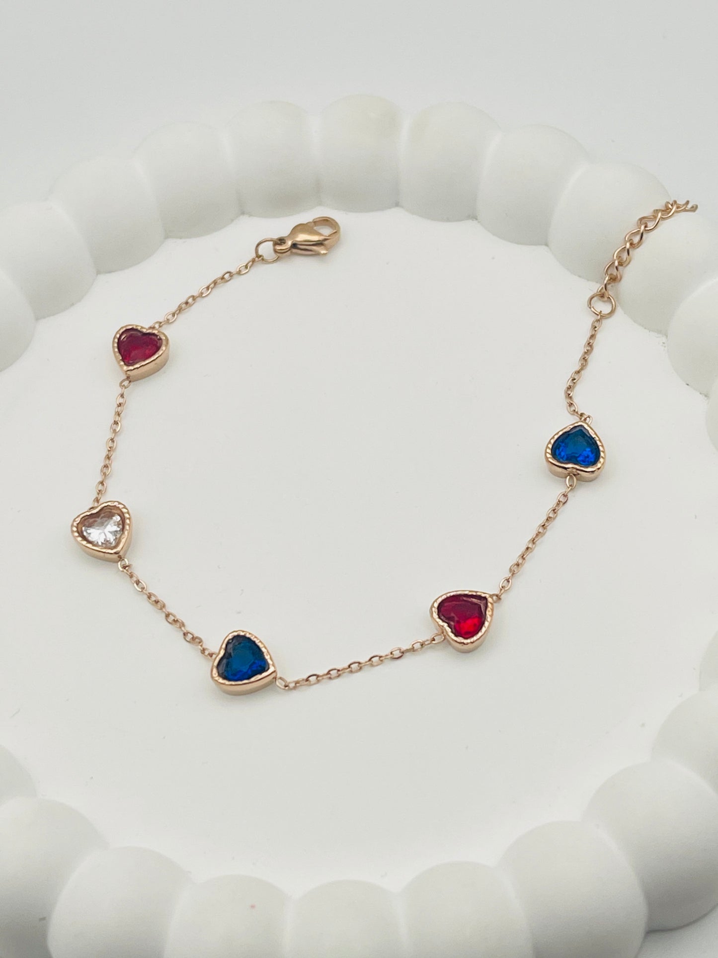 Bracelet with heart-shaped gemstones on a white cushion