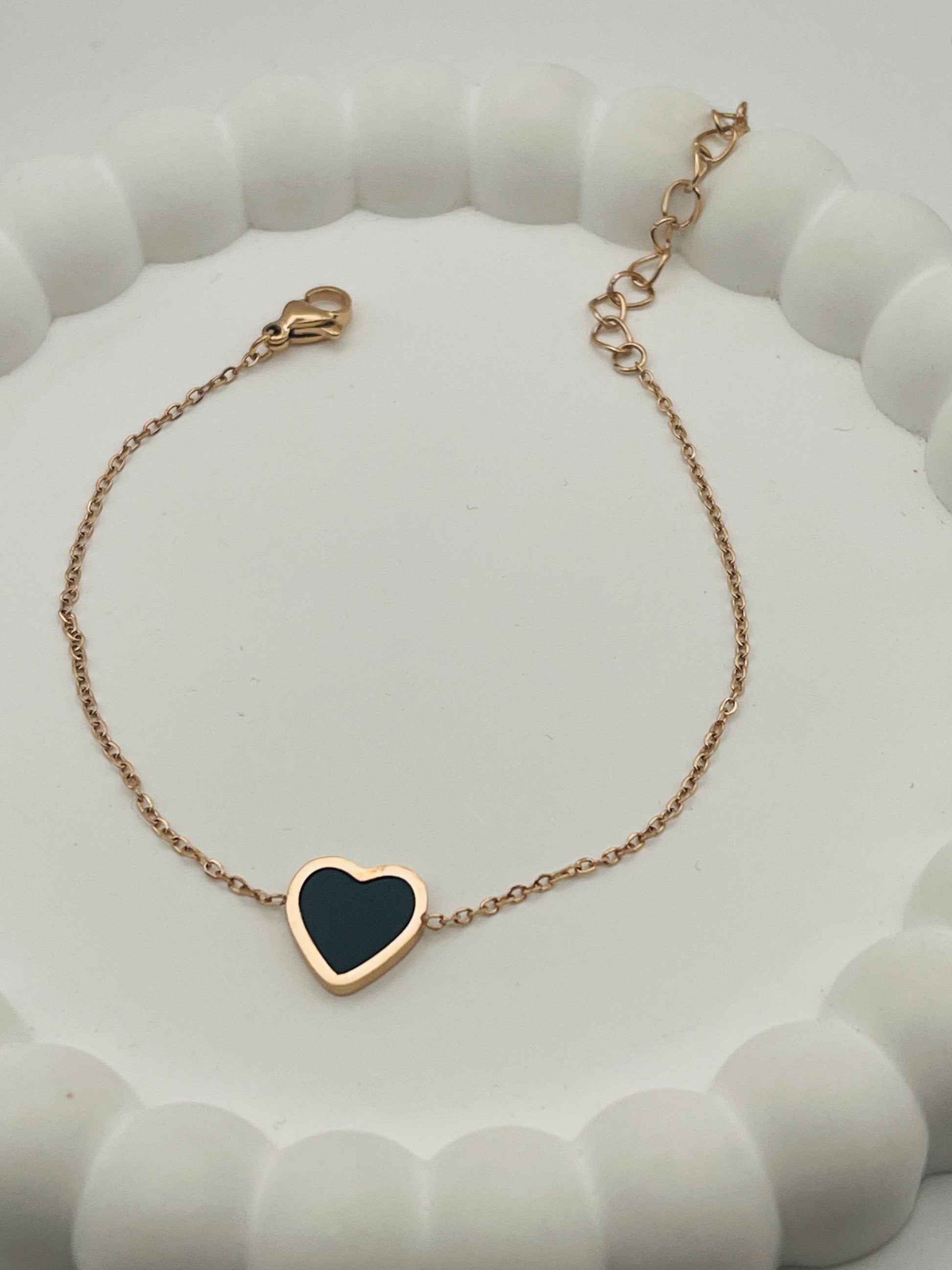 Rose Gold bracelet with a heart-shaped black stone on a white background