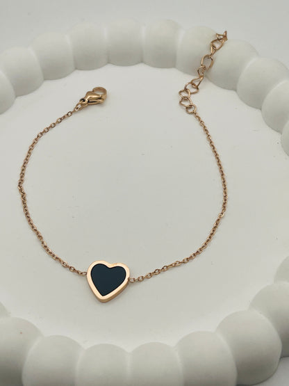 Rose Gold bracelet with a heart-shaped black stone on a white background