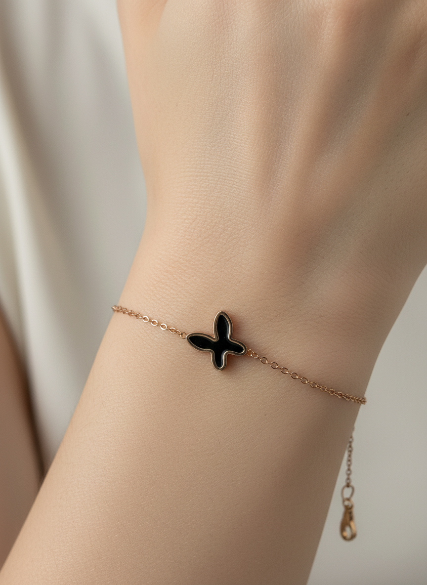 Gold bracelet with a butterfly charm on a white background