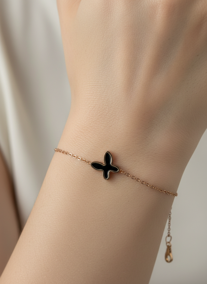 Gold bracelet with a butterfly charm on a white background