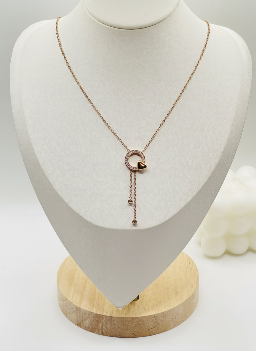 Rose gold necklace on a white mannequin bust with a wooden base.