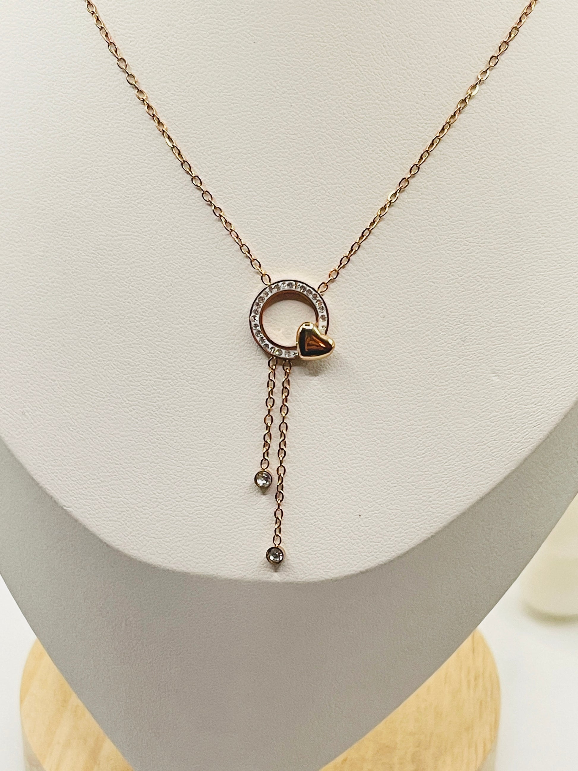 Necklace with a heart-shaped pendant on a white stand