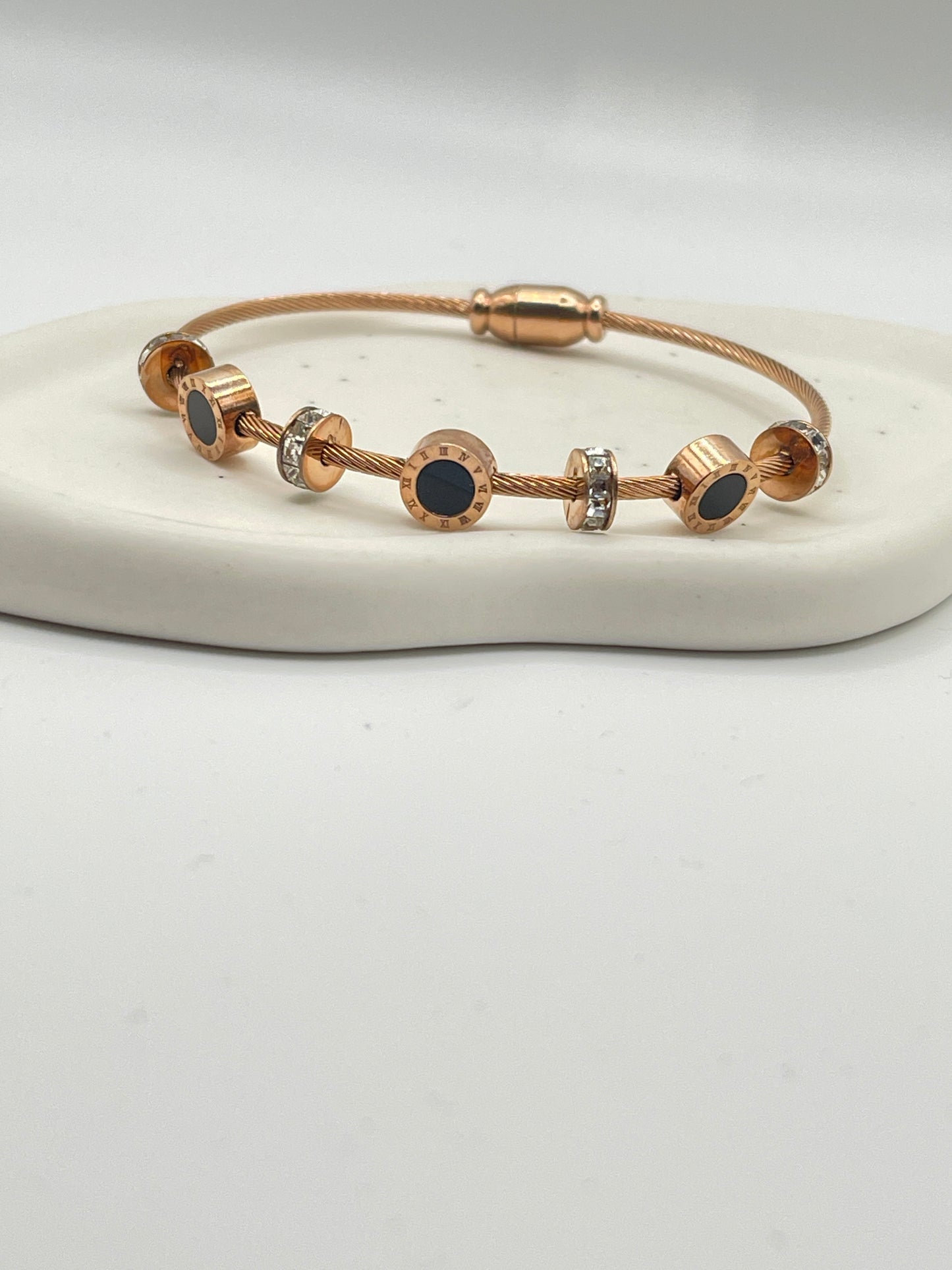 Rose Gold bracelet with black stones on a white background