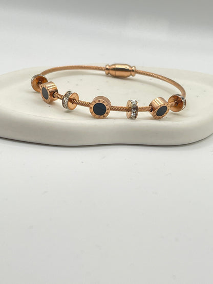 Rose Gold bracelet with black stones on a white background