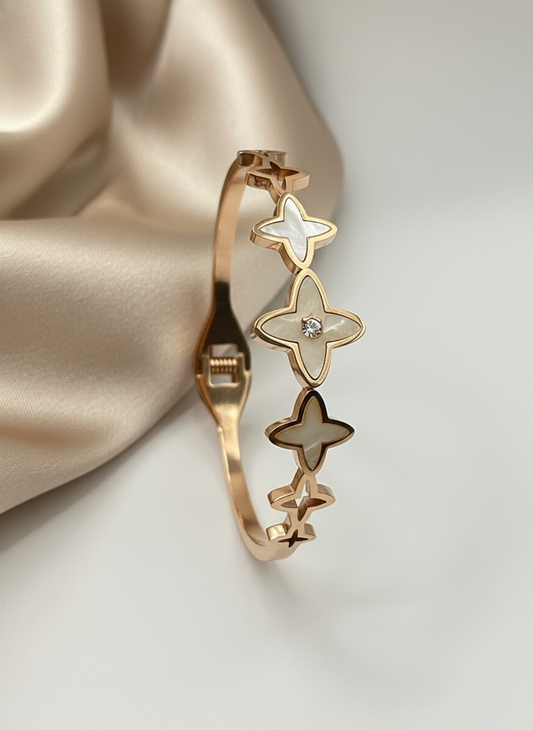 Rose Gold bracelet with star designs on a beige fabric background