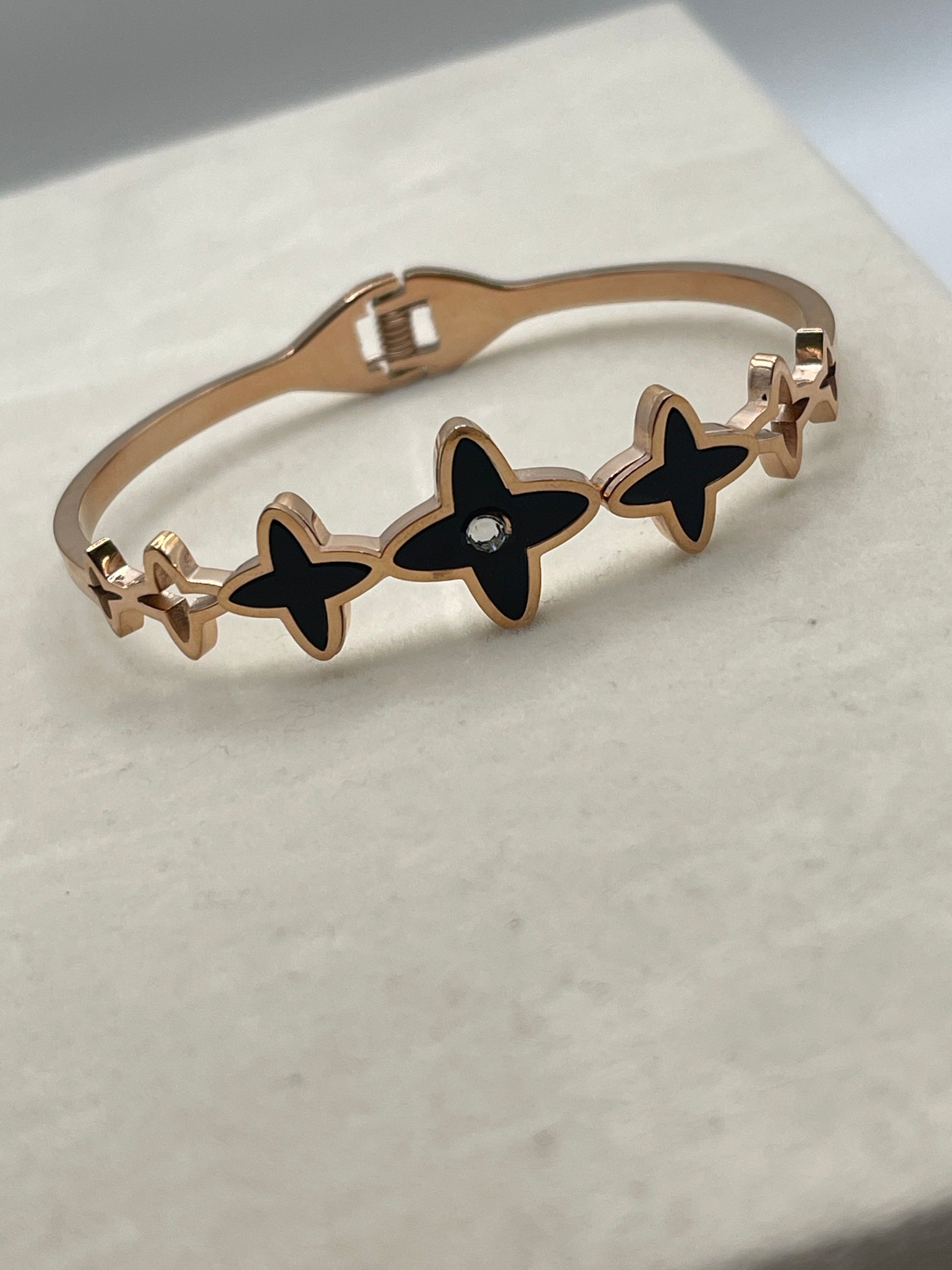 Rose Gold Bracelet with black star-shaped charms on a light background