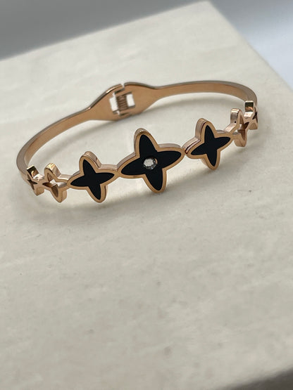 Rose Gold Bracelet with black star-shaped charms on a light background