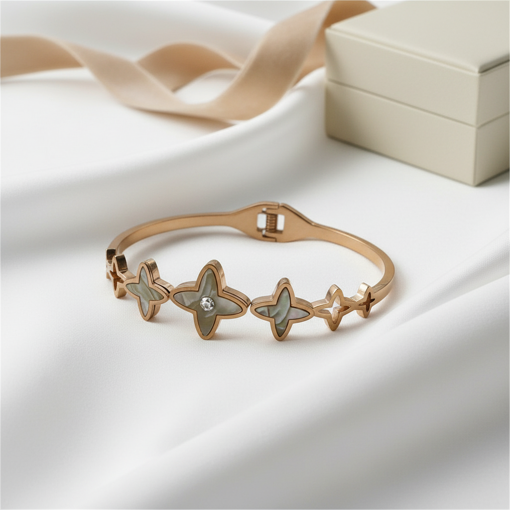 Rose gold bracelet with star designs on a white surface