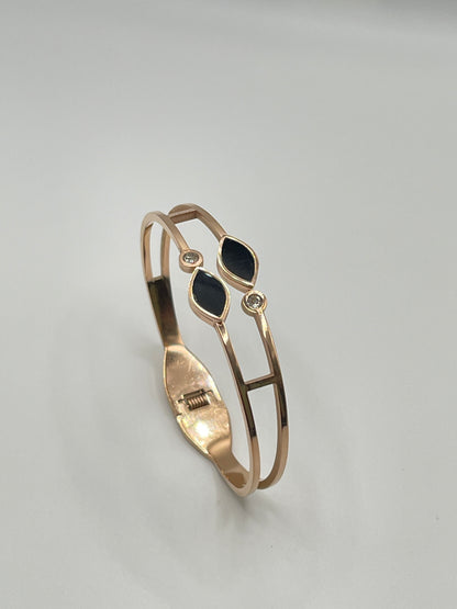 Rose Gold bracelet with black stones on a gray background