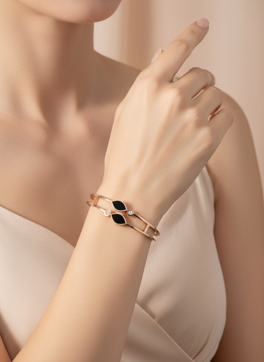 Rose gold bracelet with black heart design on a woman's wrist against a beige background