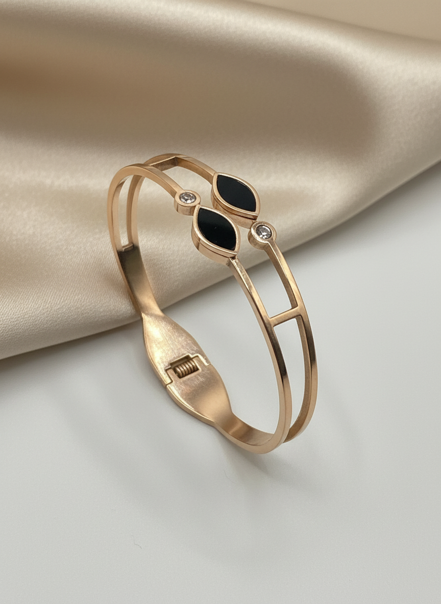 Rose Gold bracelet with black gemstone on a beige fabric background