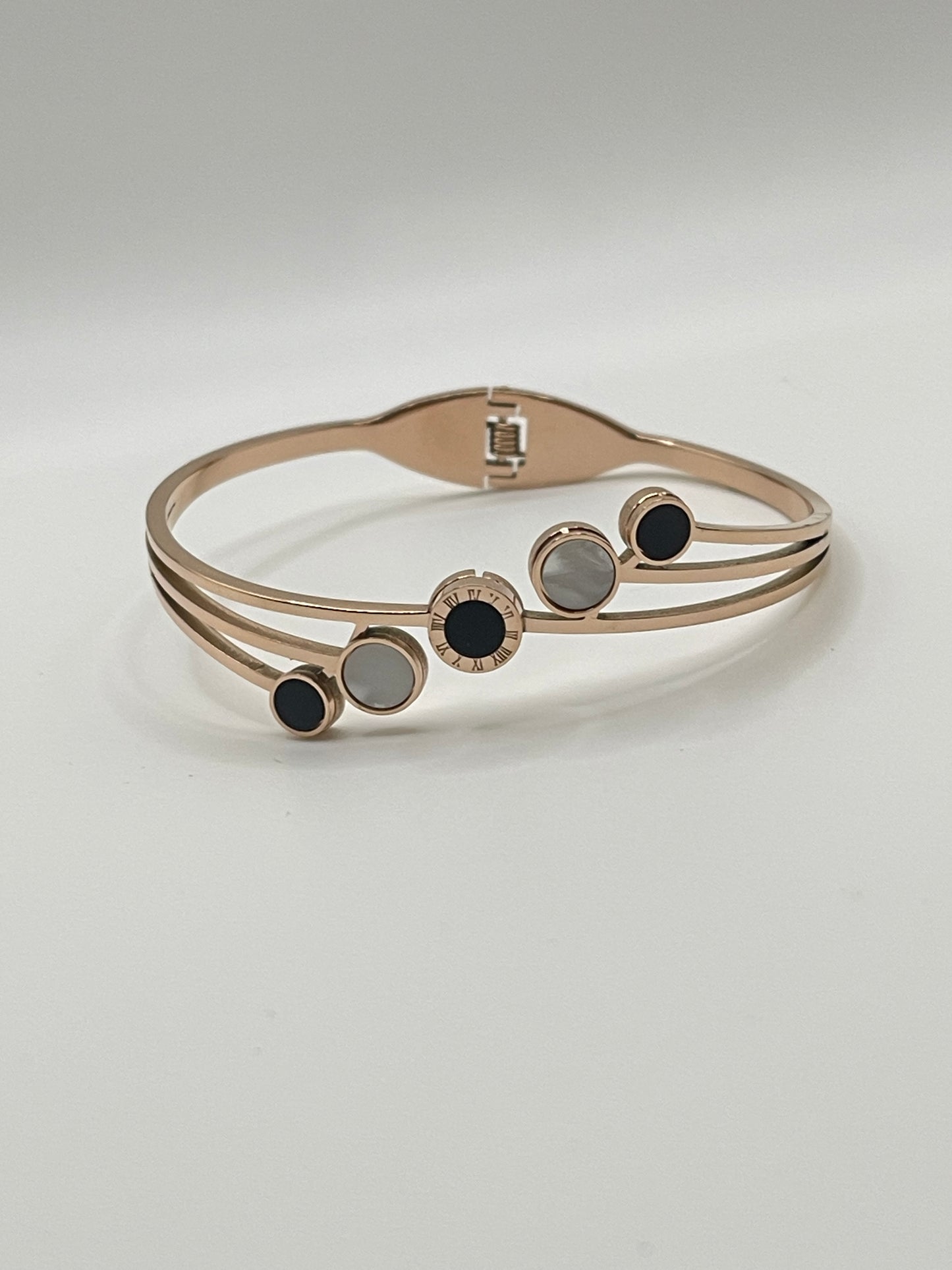 Rose Gold bracelet with black and gray accents on a light gray background
