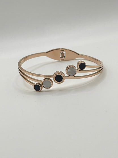 Rose Gold bracelet with black and gray accents on a light gray background