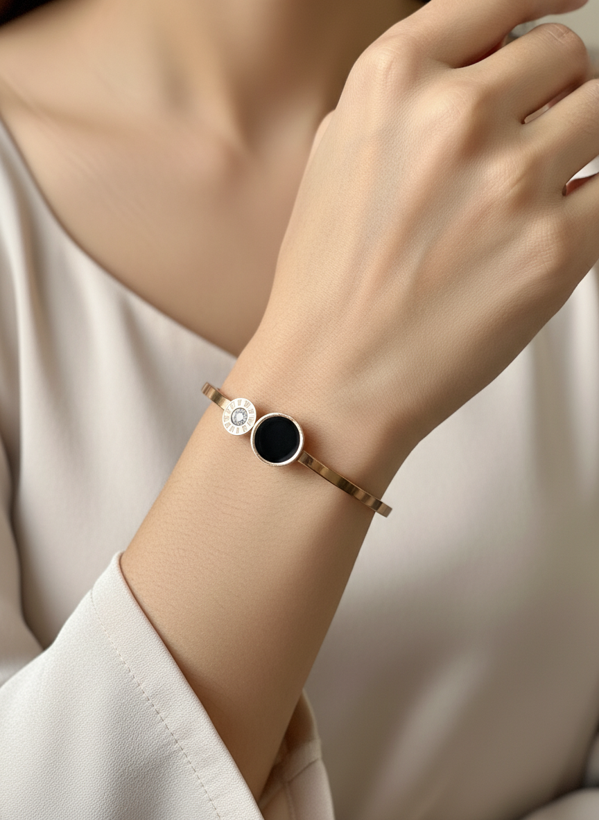 Close-up of a wrist wearing a bracelet with a black stone and silver accents on a neutral background.