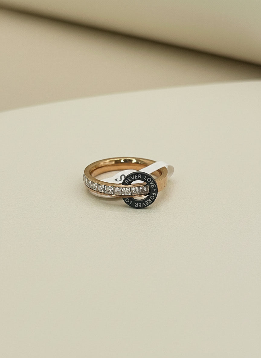 Rose Gold ring with black gemstone on a gray fabric background