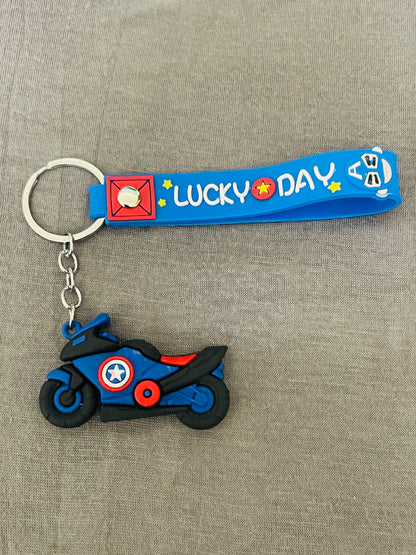 Keychain with a motorcycle design and 'LUCKY DAY' text on a gray background