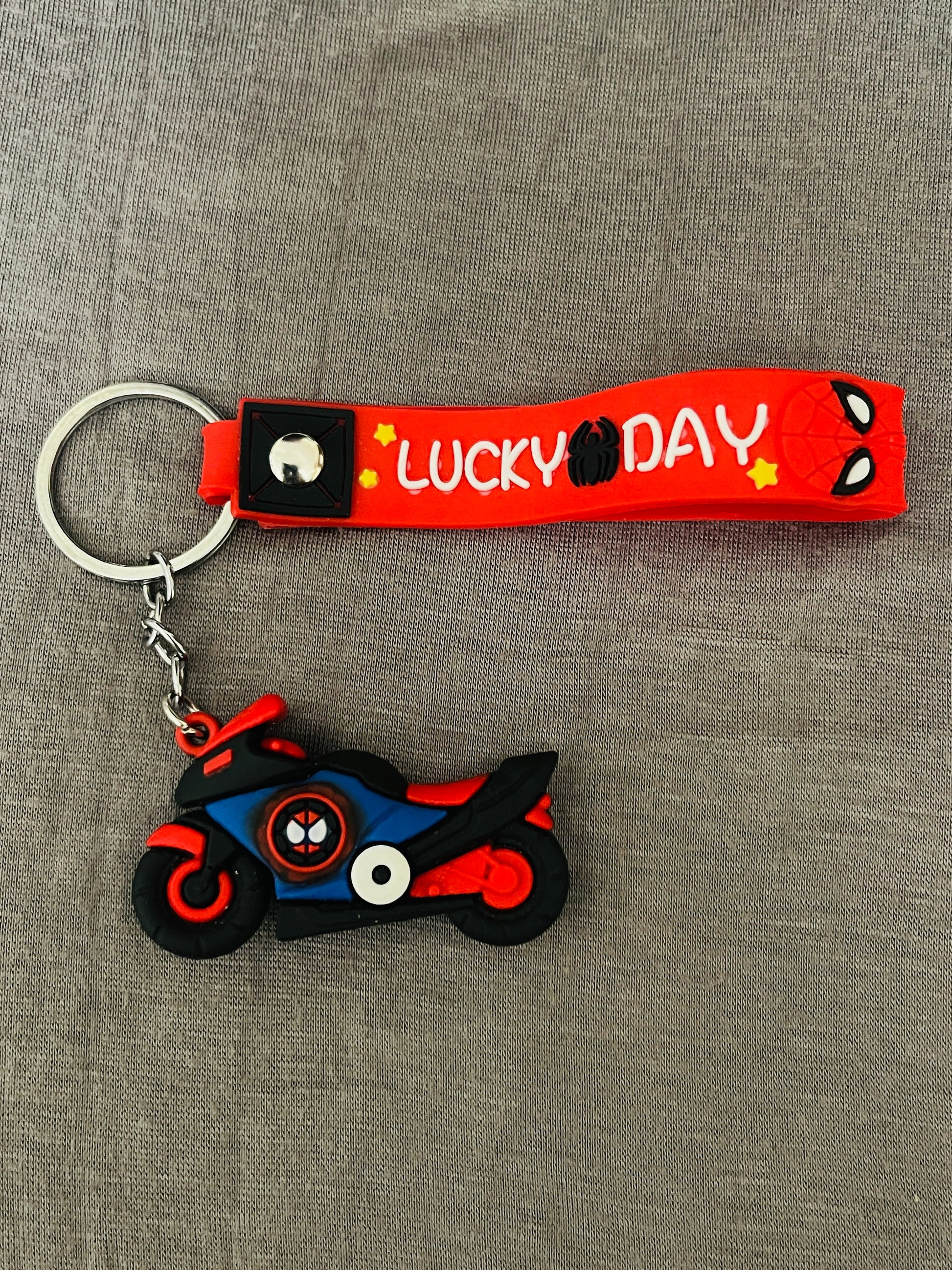 Keychain with 'Lucky Day' strap and cartoon character design on a gray background