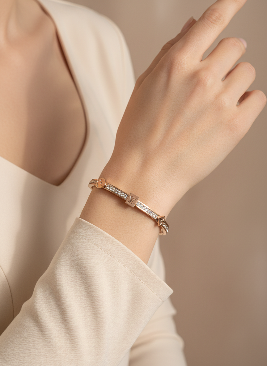 Hand wearing a rose gold bracelet with a blurred background