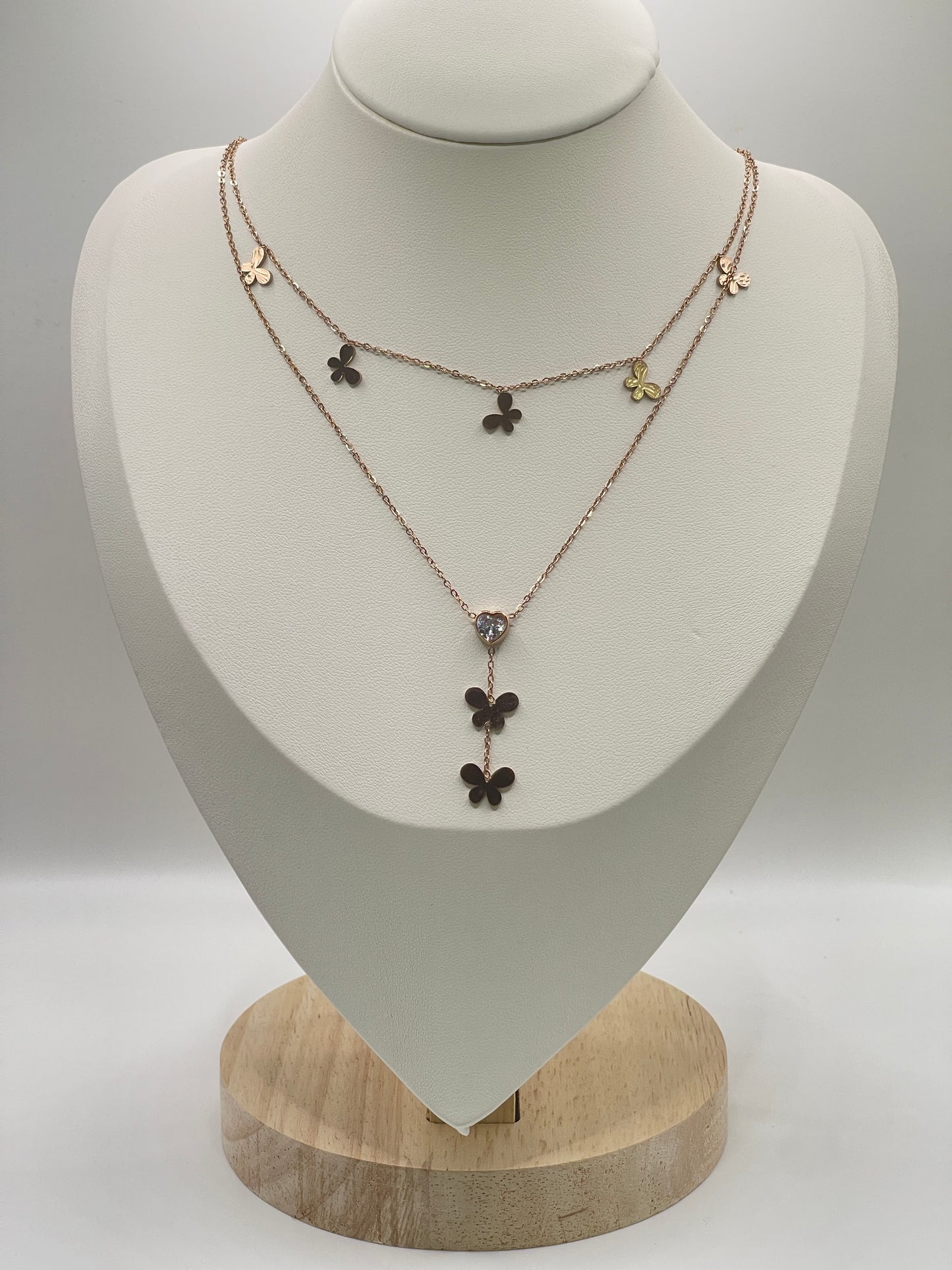 Rose gold Necklace with floral pendants on a white mannequin bust against a gray background