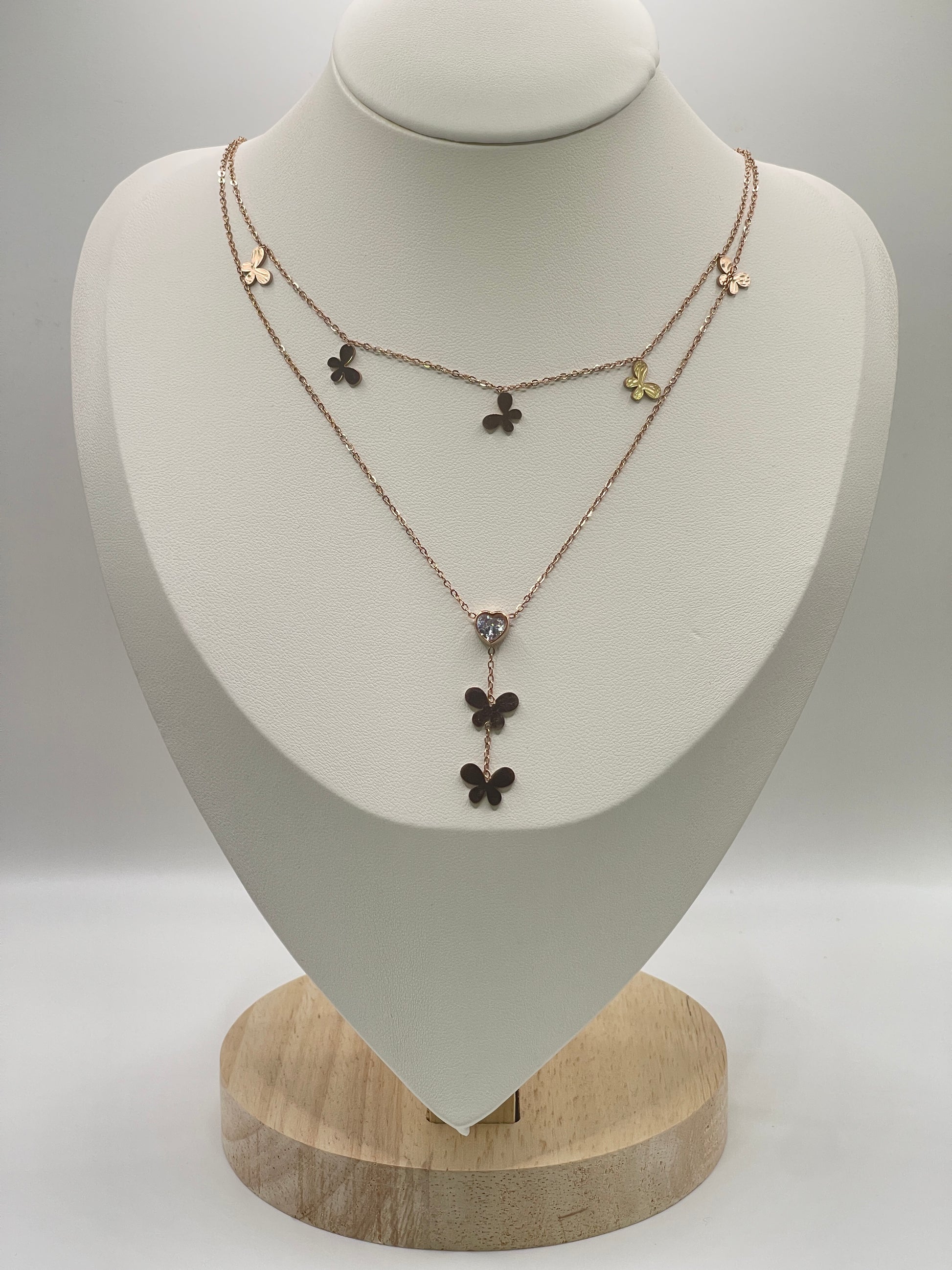 Rose gold Necklace with floral pendants on a white mannequin bust against a gray background