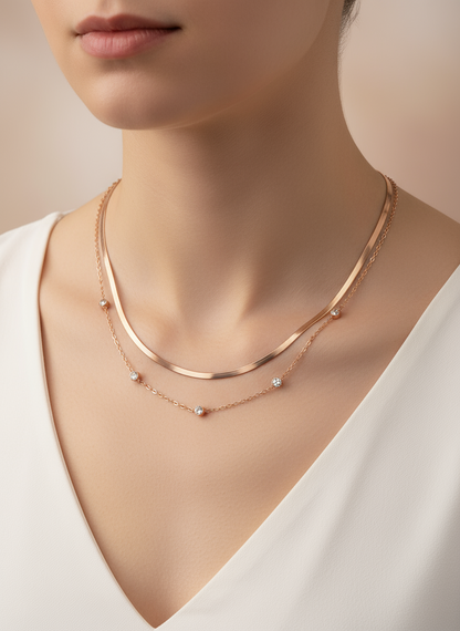 Rose gold necklace on a model wearing a white top