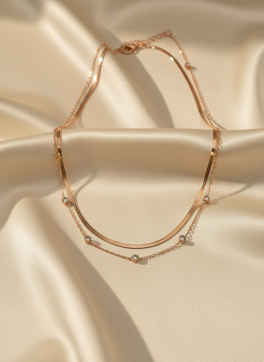 Rose gold necklace with small beads on a beige satin background