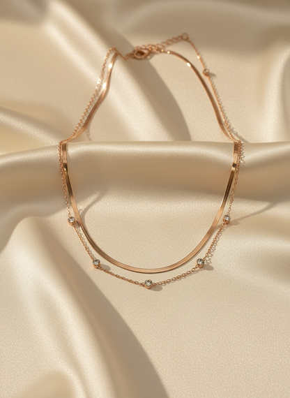 Rose gold necklace with small beads on a beige satin background