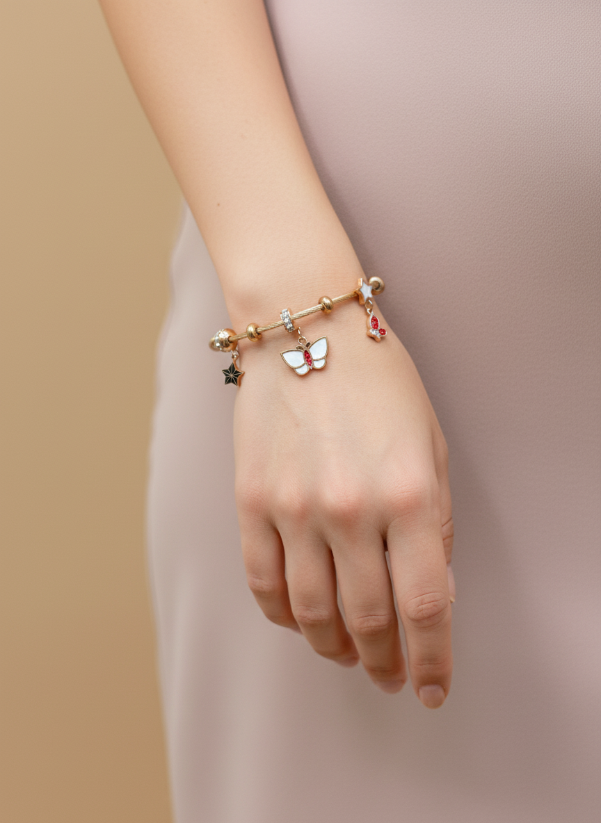 Bracelet with butterfly charm on a wrist against a beige background