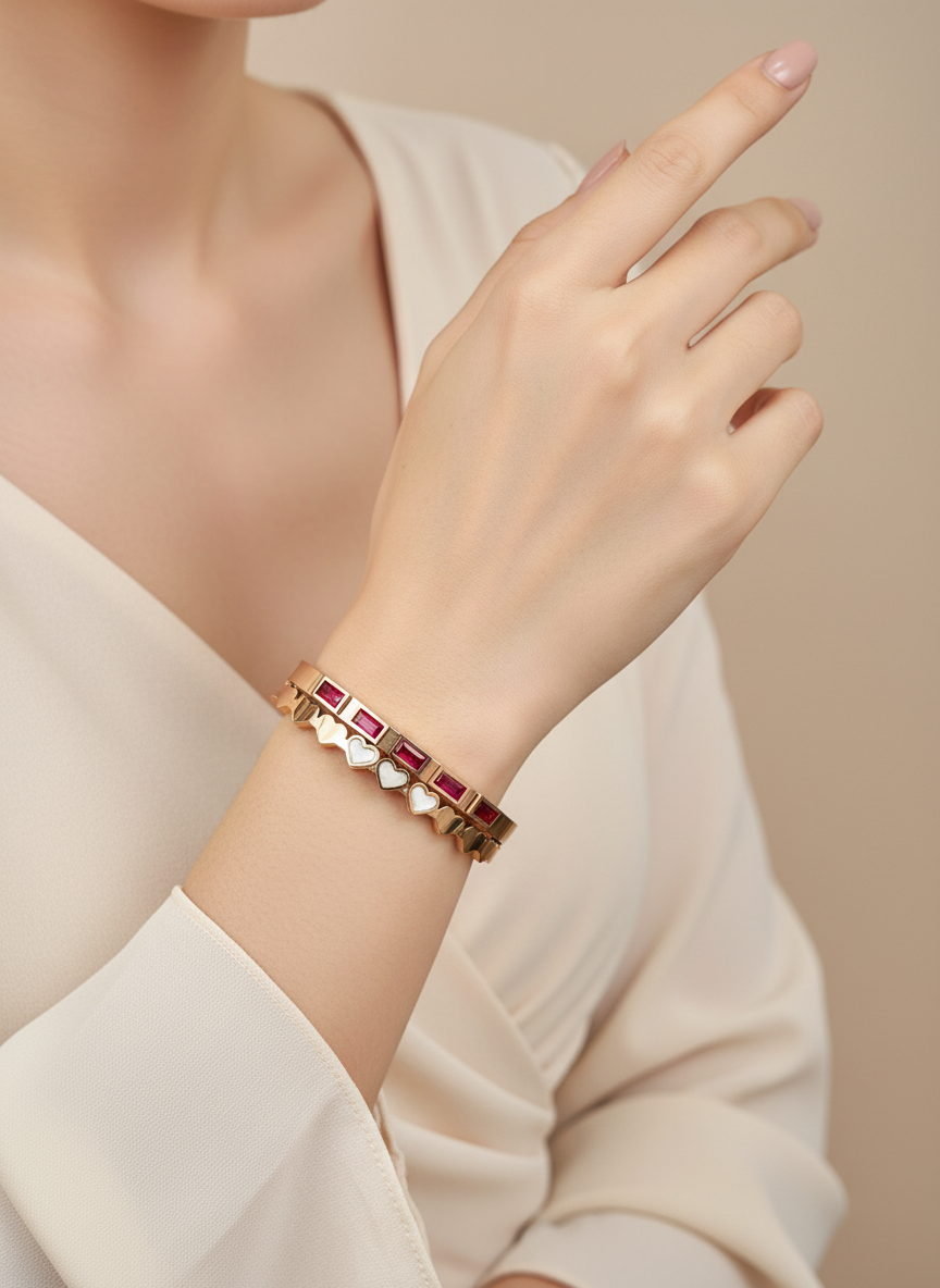 Rose Gold bracelet with red stones on a wrist against a neutral background