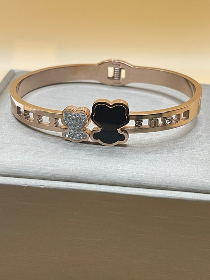 Rose Gold bracelet with black clover and diamond accents on a neutral background