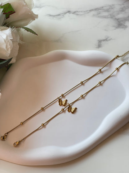 Gold necklace on a white dish with a marble background