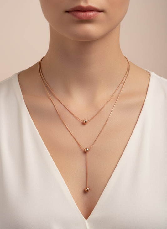 Rose gold necklace on a mannequin bust with a neutral background